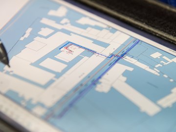 Spitze eines Stifts über einem Plan - Nahaufnahme Spitze eines Stifts über einem Plan - Nahaufnahme